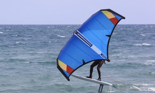 surfer-windfoil-sailing-through-waves